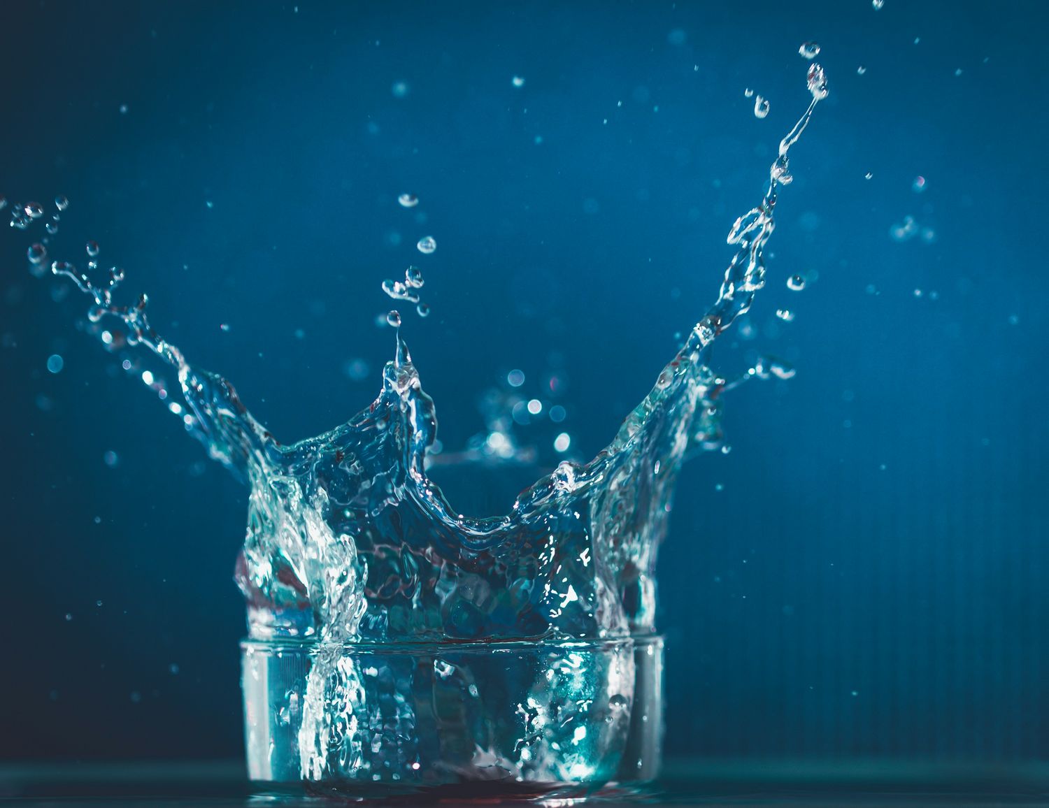 Clear water splashing up out of a glass